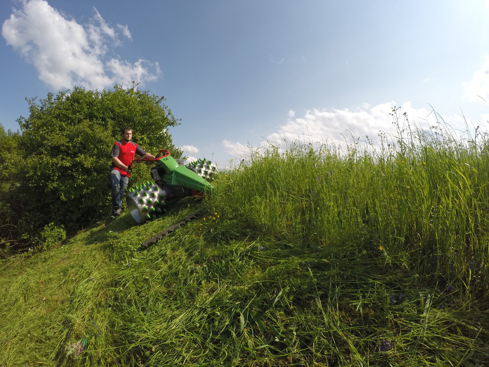 Mit dem MONTA M141 und Fingerbalken im Gras mähende Person